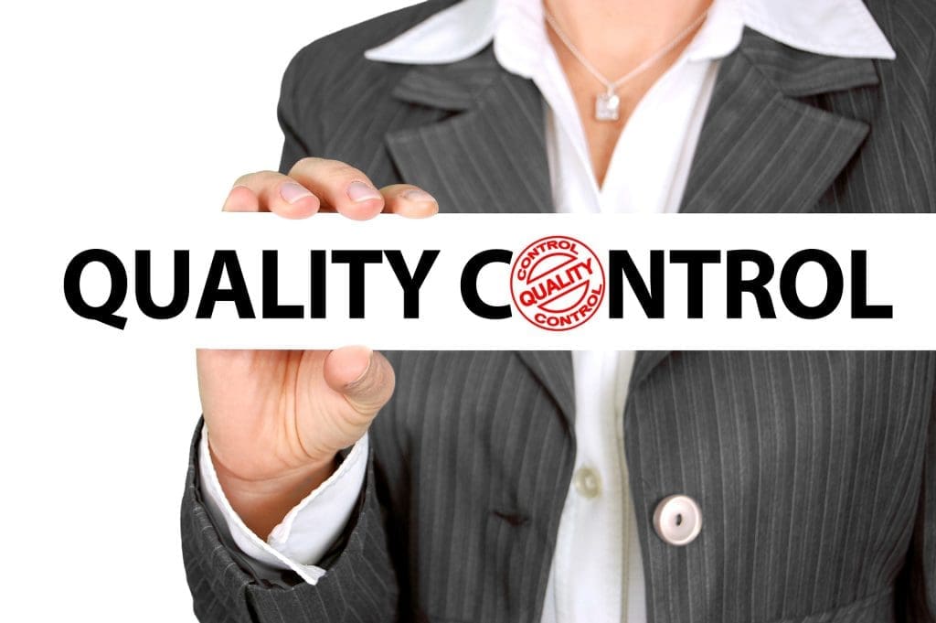 a women holds a plate labeled "quality control" 