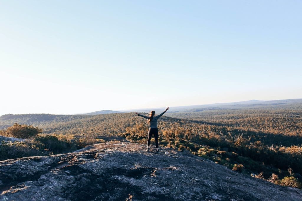 A women stands on the top of the hill