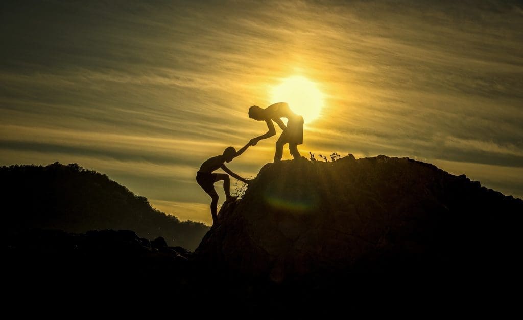 two men are climbing the hill