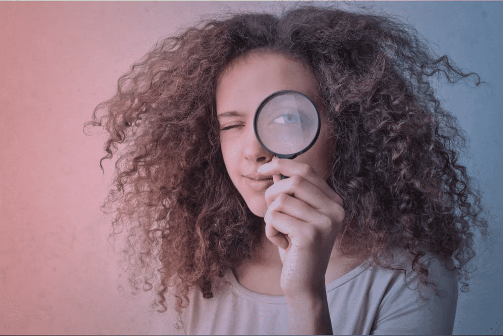 a girl with magnifier is looking for something