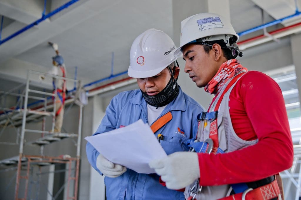 two construction workers are discussing some issue